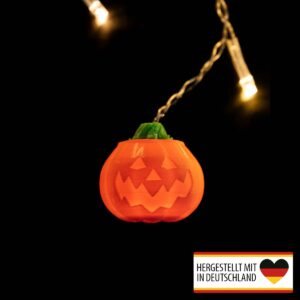 Leuchtender Halloween Kürbis Lichterketten-Aufsatz aus PLA im Einsatz an einer warmweißen Lichterkette.